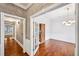 Hallway with hardwood floors, white trim, chandelier, and open doorway into the dining room at 5427 Trentham Dr, Atlanta, GA 30338