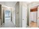 Well-lit hallway featuring carpeting, storage closets, and an open door to a bathroom at 5427 Trentham Dr, Atlanta, GA 30338