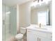 Modern bathroom with a glass shower enclosure, a white vanity, and gold accents at 164 Palm St, Holly Springs, GA 30188