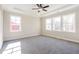 Spacious bedroom with tray ceiling, fan, neutral paint, and natural light from many windows at 164 Palm St, Holly Springs, GA 30188