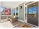 Charming front porch with wicker seating, brick floor, and a welcoming entrance at 164 Palm St, Holly Springs, GA 30188