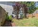 Landscaped backyard with mature trees, a patio, and an umbrella table with chairs at 4746 Highland Ave, Sugar Hill, GA 30518