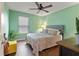 Bedroom features a patterned comforter, mint green walls, and hardwood floors at 4746 Highland Ave, Sugar Hill, GA 30518