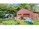 Exterior view of a detached garage with two bays and surrounding yard with garden at 5599 Redan Cir, Stone Mountain, GA 30088