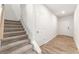 Bright hallway with wood-look flooring leading to the front door and features carpeted stairs to the second floor at 7254 Deering Court Lot 177, Douglasville, GA 30134