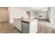 Well-lit kitchen island overlooks open floor plan with fireplace and stainless steel dishwasher at 7254 Deering Court Lot 177, Douglasville, GA 30134