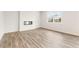 A minimalist living room bathed in neutral hues with wood flooring, a modern fireplace, and a bright window at 7254 Deering Court Lot 177, Douglasville, GA 30134