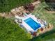 Aerial shot of the backyard featuring a pool, patio with furniture, and lush landscaping at 1076 Pinyan Ln, Canton, GA 30115