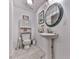 Charming half-bathroom featuring a pedestal sink, decorative mirror, and a toilet with overhead storage at 1076 Pinyan Ln, Canton, GA 30115
