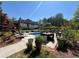 Serene backyard featuring a swimming pool, lounge chairs, dining set, and lush greenery at 1076 Pinyan Ln, Canton, GA 30115