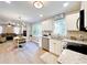 Bright eat-in kitchen with white cabinets, stainless steel appliances, and hardwood flooring at 430 Thornbush Trce, Lawrenceville, GA 30046