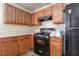Well-lit kitchen featuring matching wood cabinets, black oven, and laminate countertops at 6341 Lake Valley Pt, Lithonia, GA 30058