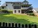 A view of a level, grassy backyard, a small deck, and the rear exterior of the house at 710 Larkspur Nw Blvd, Acworth, GA 30102