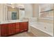 Bathroom featuring double sinks, large mirror, and soaking tub at 1755 Rutland Pass Dr, Lawrenceville, GA 30045