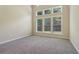 An empty bedroom featuring three large windows and plush carpeting at 1755 Rutland Pass Dr, Lawrenceville, GA 30045