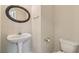 Half bath featuring a pedestal sink and oval mirror at 1755 Rutland Pass Dr, Lawrenceville, GA 30045