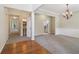 Inviting open-concept living area with neutral paint, modern chandelier, carpeted floors and wood accents at 1755 Rutland Pass Dr, Lawrenceville, GA 30045