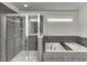 Bathroom featuring a walk-in shower and soaking tub with tile surround at 1830 Secretariat Gait Way, Suwanee, GA 30024