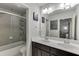 Clean bathroom featuring a double vanity, large mirror, and tiled shower with glass door at 1830 Secretariat Gait Way, Suwanee, GA 30024