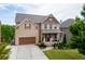 The home features a brick exterior, a well-manicured lawn, and a welcoming front porch at 1830 Secretariat Gait Way, Suwanee, GA 30024