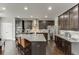 A modern kitchen with stainless steel appliances, a center island, and dark cabinets at 1830 Secretariat Gait Way, Suwanee, GA 30024