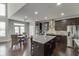 Well-lit kitchen features dark cabinetry, stainless steel appliances, and a granite island with seating at 1830 Secretariat Gait Way, Suwanee, GA 30024