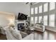 Sun-filled living room boasts high ceilings, a fireplace, and an arrangement of modern furniture at 1830 Secretariat Gait Way, Suwanee, GA 30024