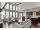 Spacious living room with large windows, open to the kitchen, featuring hardwood floors at 1830 Secretariat Gait Way, Suwanee, GA 30024