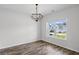 Bright dining room featuring hardwood floors, a modern chandelier, and large window with a view of the neighborhood at 230 Waters Edge Pkwy, Temple, GA 30179
