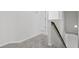 Hallway featuring neutral carpeting and a dark wood handrail for a comfortable and stylish transition between rooms at 230 Waters Edge Pkwy, Temple, GA 30179