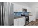 Modern kitchen with stainless steel appliances, white cabinets, gray countertops, and a blue backsplash at 230 Waters Edge Pkwy, Temple, GA 30179