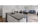 Kitchen island features white cabinets, stone countertop, stainless dishwasher, and bar seating open to living area at 230 Waters Edge Pkwy, Temple, GA 30179