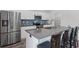 Stylish kitchen features stainless appliances, white cabinets, a gray island with seating, and a blue backsplash at 230 Waters Edge Pkwy, Temple, GA 30179