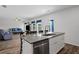 Kitchen island features white cabinets, stone countertop, stainless dishwasher, and bar seating open to living area at 230 Waters Edge Pkwy, Temple, GA 30179