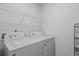 The laundry room features a white washer and dryer, metal shelving, and a nearby electrical outlet at 230 Waters Edge Pkwy, Temple, GA 30179