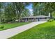 Single story home with a long driveway, well manicured lawn and mature trees at 2463 Briarmoor Ne Rd, Atlanta, GA 30345
