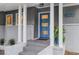 Stylish covered front porch with a bright blue front door, white pillars, and brick accents at 2463 Briarmoor Ne Rd, Atlanta, GA 30345