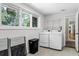 Laundry room with white appliances, a window view, and tile flooring at 2463 Briarmoor Ne Rd, Atlanta, GA 30345