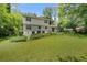 White two-story home with a well-manicured lawn, lush greenery, and a serene backyard ambiance at 4389 Hambrick Way, Stone Mountain, GA 30083