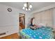 Cozy bedroom featuring hardwood floors, a patterned bedspread, and a glimpse into the adjacent kitchen area at 4389 Hambrick Way, Stone Mountain, GA 30083