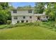 Two-story home featuring a white brick exterior, surrounded by lush greenery, offering a serene backyard view at 4389 Hambrick Way, Stone Mountain, GA 30083