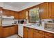 Cozy kitchen with wood cabinets, stainless steel appliances, and a window overlooking the backyard at 4389 Hambrick Way, Stone Mountain, GA 30083