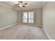 Neutral primary bedroom with tan carpet, ceiling fan, and view to the backyard at 1010 Donegal Se, Smyrna, GA 30080