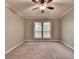Neutral bedroom with tan carpet, ceiling fan, and view to the backyard at 1010 Donegal Se, Smyrna, GA 30080