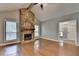 Open living room featuring hardwood floors, stone fireplace, and natural light from multiple windows at 1010 Donegal Se, Smyrna, GA 30080
