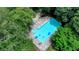 Aerial shot of a sparkling community pool surrounded by mature trees and lounge chairs at 1010 Donegal Se, Smyrna, GA 30080