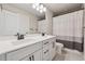 Well-lit bathroom with double vanity, framed mirrors, matte black fixtures, and white/gray striped shower curtain at 1104 Knoxboro Ln, Woodstock, GA 30188