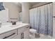 Clean, well-lit bathroom featuring a vanity with sink, toilet, and shower with a patterned curtain at 1104 Knoxboro Ln, Woodstock, GA 30188