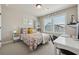 Bright bedroom featuring a floral print bedspread, a desk, and large windows at 1104 Knoxboro Ln, Woodstock, GA 30188