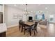 Bright dining area open to the living room features wood floors and modern lighting at 1104 Knoxboro Ln, Woodstock, GA 30188